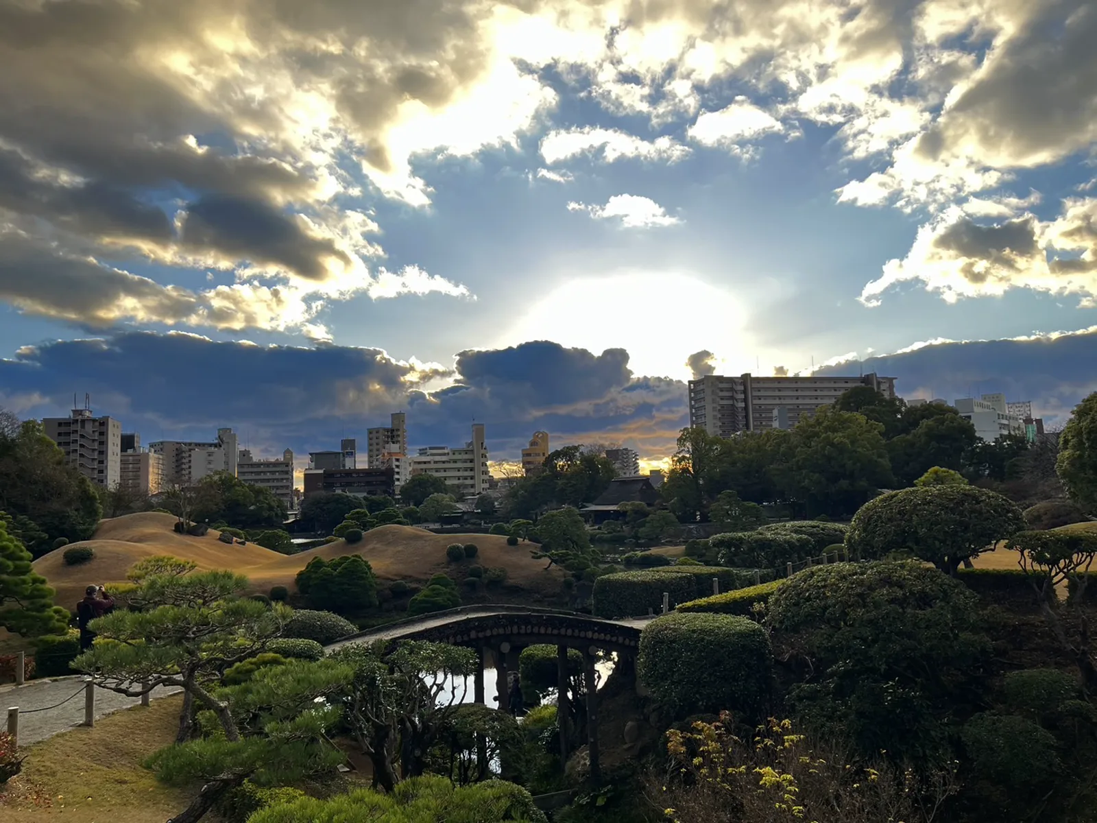 松屋本館 水前寺成趣園 — 石橋と庭園越しに望む熊本市街